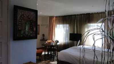 a bedroom with a bed and a table and a window at Rijnzicht in Alphen aan den Rijn