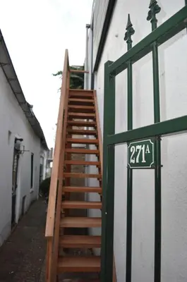 a wooden staircase next to a building with a sign at Rijnzicht in Alphen aan den Rijn