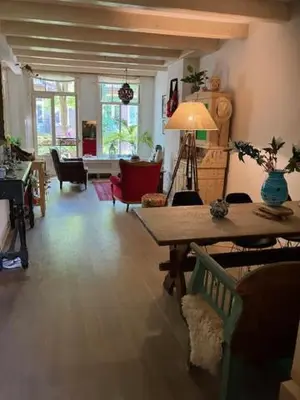 a living room with a wooden table and a dining room at Bohemian loft in Amsterdam