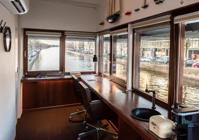 an office with a desk and windows in a boat at SWEETS - Zeilstraatbrug in Amsterdam