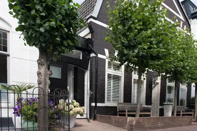 a black and white house with trees and flowers at Zandvoort Studio in Zandvoort