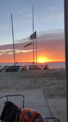 two sailboats on the beach with the sunset in the background at Zandvoort Studio in Zandvoort