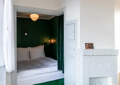 a bedroom with a bed with a green wall at SWEETS - Overtoomsesluis in Amsterdam