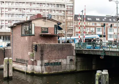 a train on a bridge over a body of water at SWEETS - Overtoomsesluis in Amsterdam