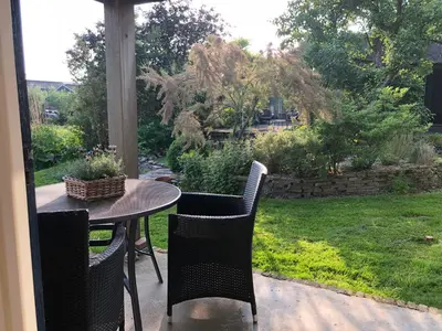 a table and chairs on a patio with a yard at Slapen op het platteland in Bodegraven