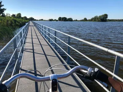 a boat on the water with a bridge at Slapen op het platteland in Bodegraven
