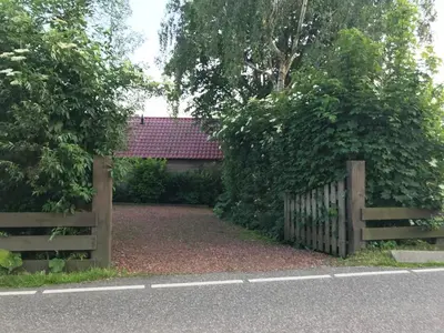 a wooden fence in front of a house at Slapen op het platteland in Bodegraven