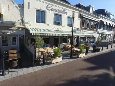 a building with tables and chairs on a city street at Hostel 45 in Purmerend