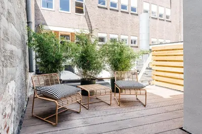 three chairs and a table on a wooden deck at Cozy Pillow in Utrecht