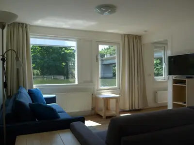 a living room with a couch and two windows at Apartment at the East side, close to center in Amsterdam
