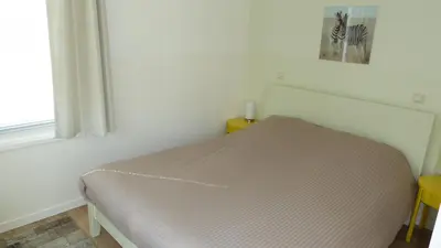 a bed sitting in a room with a window at Apartment at the East side, close to center in Amsterdam
