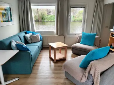a living room with a blue couch and two chairs at Apartment at the East side, close to center in Amsterdam