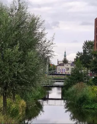 a river in a city with a bridge and buildings at LandLust Guesthouse B&B Amsterdam Area Purmerend in Purmerend