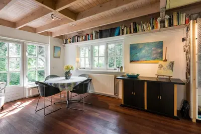 a dining room with a table and chairs and windows at Unique Atelier in Bergen in Bergen