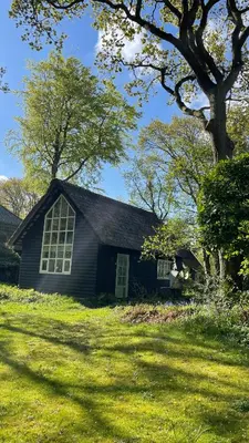 a black house with a window and a tree at Unique Atelier in Bergen in Bergen