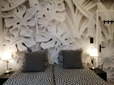 a bedroom with a white wall with a bed and two lamps at Pension Schier in Zandvoort