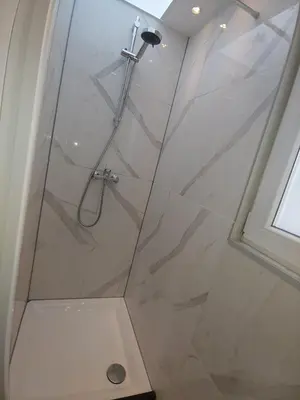 a bathroom with a shower with a glass door at Pension Schier in Zandvoort