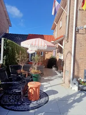 a patio with a table and chairs and an umbrella at Pension Schier in Zandvoort