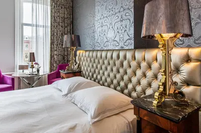 a bedroom with a large bed and a lamp on a table at Amstel Corner Hotel in Amsterdam