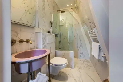 a bathroom with a sink and a toilet and a shower at Amstel Corner Hotel in Amsterdam