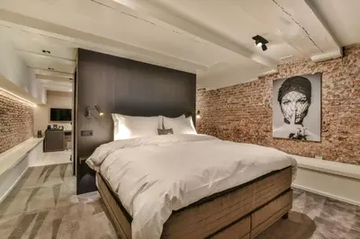 a bedroom with a brick wall and a large bed at Luxury Canal Suite De Heren in Amsterdam