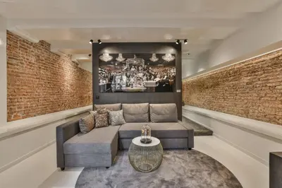 a living room with a couch and a brick wall at Luxury Canal Suite De Heren in Amsterdam