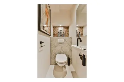 a bathroom with a toilet and a sink at Luxury Canal Suite De Heren in Amsterdam
