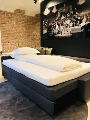two large beds in a room with a picture on the wall at Luxury Canal Suite De Heren in Amsterdam