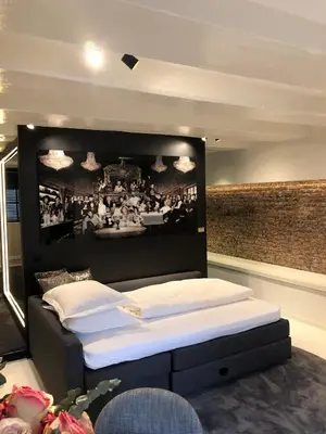 a room with two beds with a picture on the wall at Luxury Canal Suite De Heren in Amsterdam