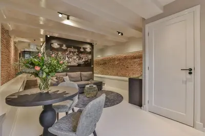 a living room with a table and chairs and a couch at Luxury Canal Suite De Heren in Amsterdam
