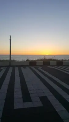 an empty parking lot with the sunset in the background at Near the Beach in Zandvoort