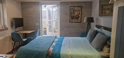 a bedroom with a bed and a desk and a television at Near the Beach in Zandvoort