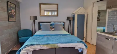 a bedroom with a bed and a sink and a mirror at Near the Beach in Zandvoort