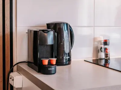 a coffee maker and coffee cups sitting on a counter at Casa del Mar Zandvoort in Zandvoort