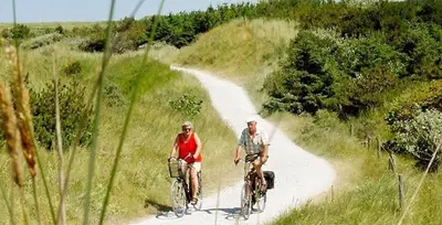 two people riding bikes on a dirt road at Casa del Mar Zandvoort in Zandvoort