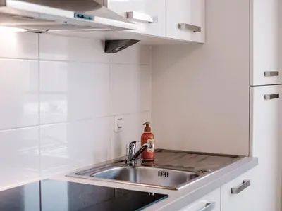 a kitchen with a sink and a refrigerator at Casa del Mar Zandvoort in Zandvoort