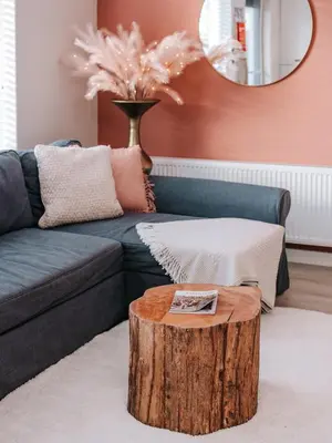 a living room with a blue couch and a tree stump coffee table at Casa del Mar Zandvoort in Zandvoort