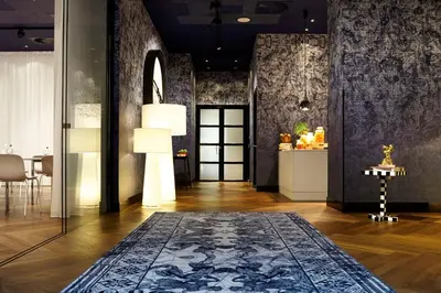 a living room with a blue rug on the floor at Andaz Amsterdam, Prinsengracht, By Hyatt in Amsterdam