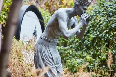 a statue of a boy eating a piece of food at Andaz Amsterdam, Prinsengracht, By Hyatt in Amsterdam
