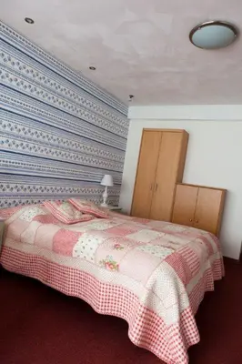 a bedroom with a bed and a blue wall at Appartementen Bergen aan Zee de Schelp in Bergen aan Zee