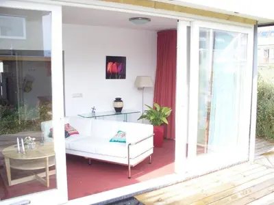 a living room with a white couch and a table at Appartementen Bergen aan Zee de Schelp in Bergen aan Zee