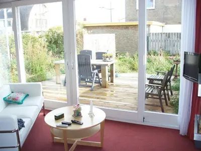 a living room with a large sliding glass door at Appartementen Bergen aan Zee de Schelp in Bergen aan Zee