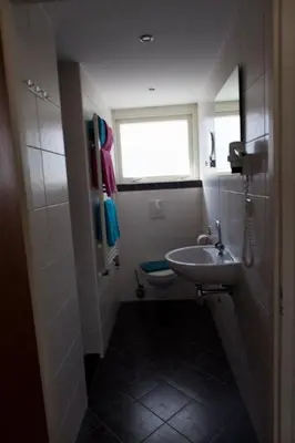 a small bathroom with a sink and a toilet at Appartementen Bergen aan Zee de Schelp in Bergen aan Zee