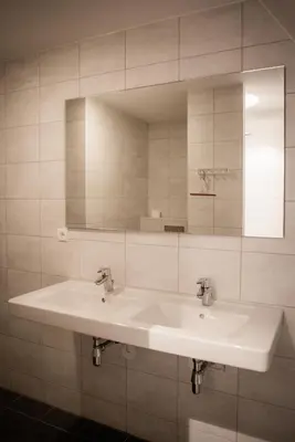 a bathroom with a white sink and a mirror at Villa Zeezicht in Noordwijk