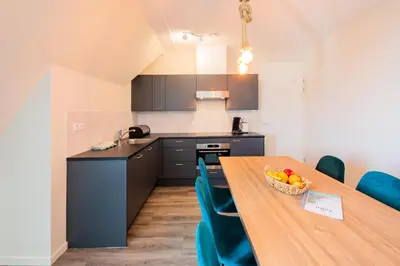 a kitchen with a wooden table with a bowl of fruit on it at Villa Zeezicht in Noordwijk