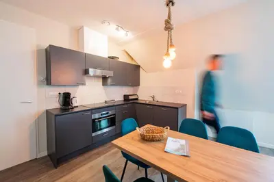 a kitchen with a wooden table and blue chairs at Villa Zeezicht in Noordwijk