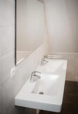 a bathroom with a white sink and a mirror at Villa Zeezicht in Noordwijk