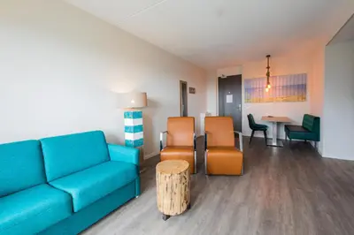 a living room with a couch and chairs and a table at Villa Zeezicht in Noordwijk