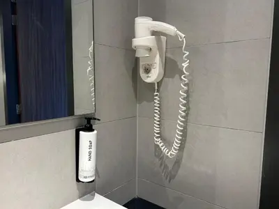 a phone hanging on a wall in a bathroom at XO Hotels Park West in Amsterdam