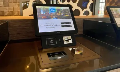 a tablet computer sitting on top of a glass table at XO Hotels Park West in Amsterdam